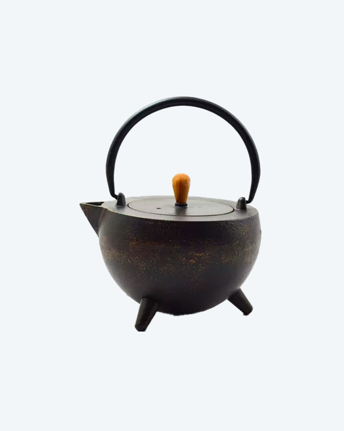 Cast iron, pot-bellied tea pot in black and gold with wooden lid handle and arcing iron pot handle.