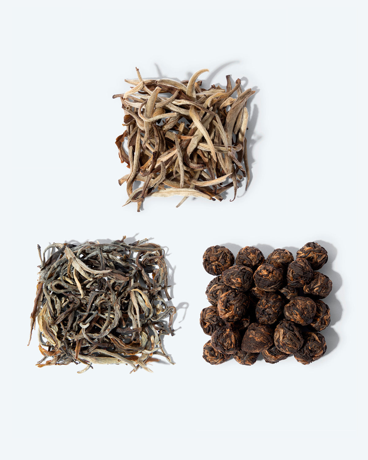Three special Chinese teas. Jasmine silver needle, young white buds scented with jasmine flowers, black jasmine pearls featuring mellow leaves tipped with orange and also scented with jasmine, and fine yellow tea, soft in color.